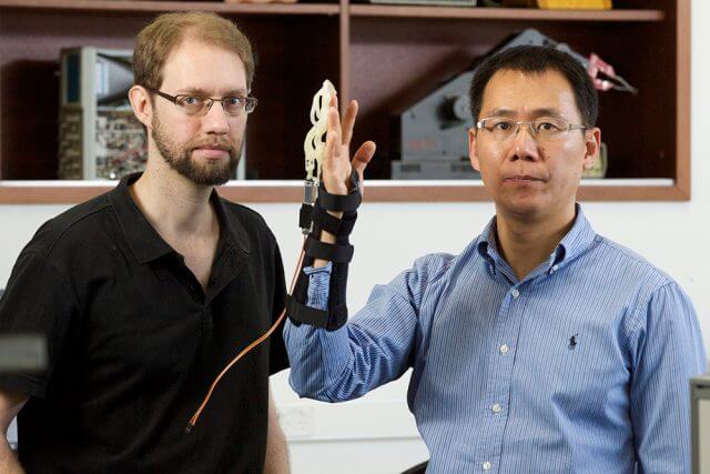 Otto Seyfarth and Lei Cui from Curtin university with the finger exoskeleton. Photograph — Matt Devlin.