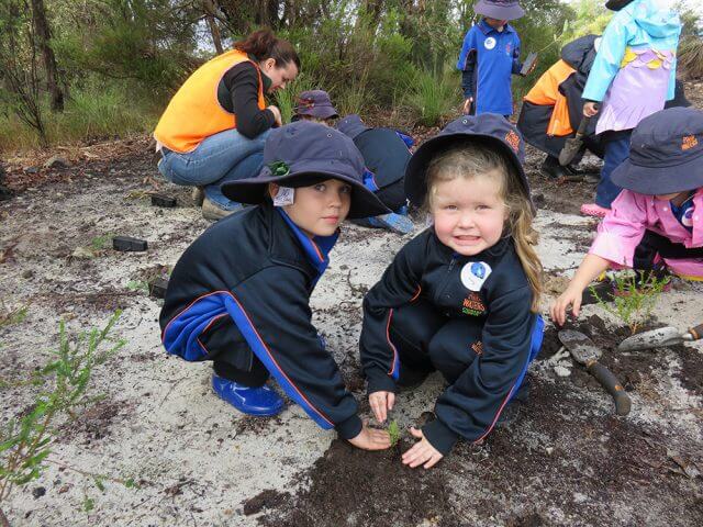 Campbell primary school kindergarten students James Lee and Holly Carter learn about the importance of tree planting.