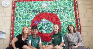 Art teacher Merranie Beal with headboy Akshay Sundru, headgirl Paris Scoby-Smith and principal Patricia Joss in front of the school’s mural. Photograph — Matt Devlin.