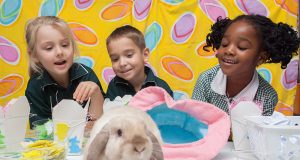Preprimary students Rio Foster, Michael Penny and Sephtricia Newman show Fella their Easter themed arts and crafts. Photograph — Matt Devlin.