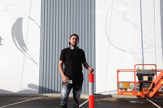 Contemporary artist Chris Nixon is painting a mural of local and migratory birds. Photograph — Matt Devlin