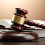 wooden gavel and books on wooden table,on brown background