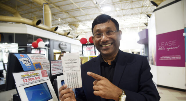 Man pointing at lotto ticket.