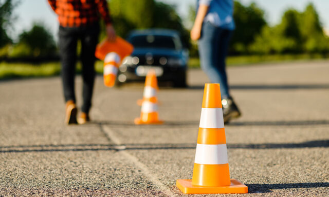 Instructor and student on road with traffic cones